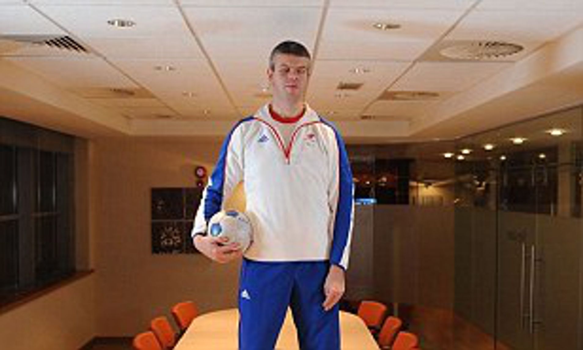 David Clarke holding a football standing on a table