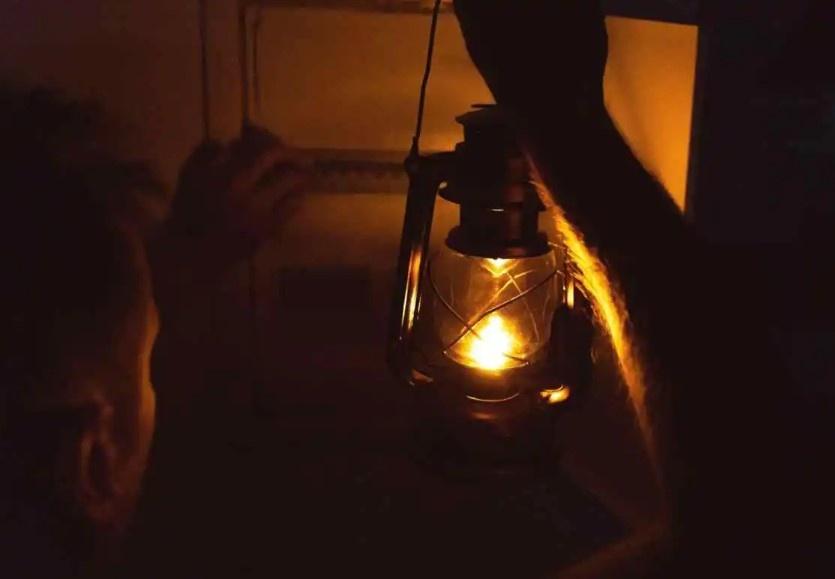 ft.com person holding a lantern in darkness
